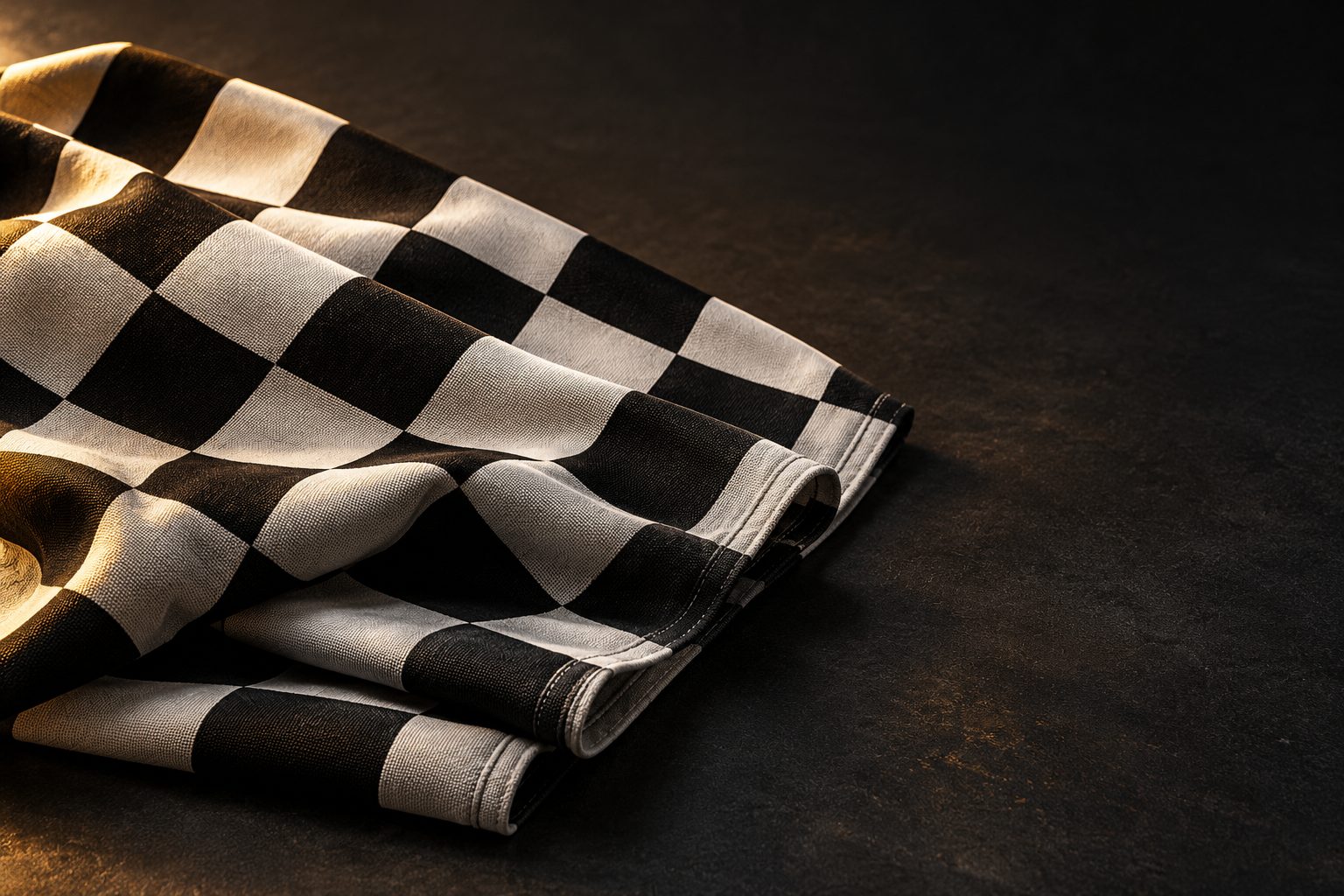 Folded black-and-white chequered flag on a dark surface